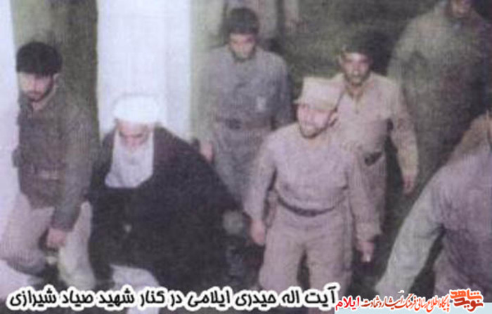 آیت اله حیدری ایلامی در کنار شهید صیاد شیرازی و جمعی از رزمندگان در دوران دفاع مقدس